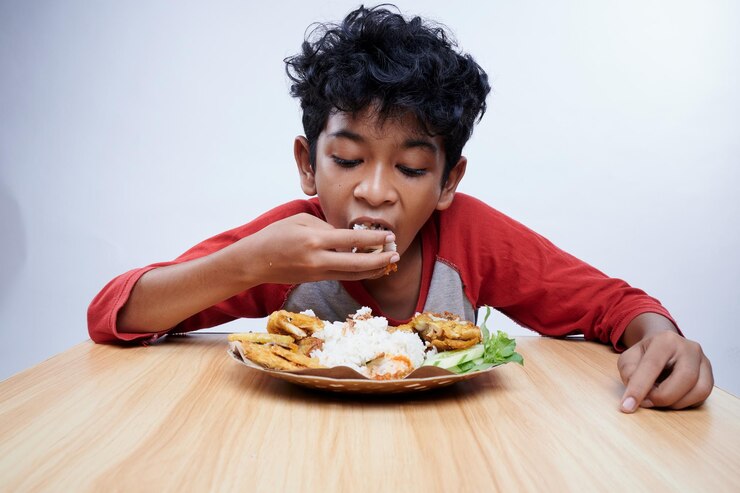 Photo un enfant mange du poulet frit et du riz pour le déjeuner.