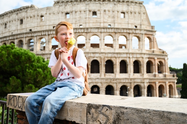 Un enfant mange de la glace au Colisée. Italie, Rome