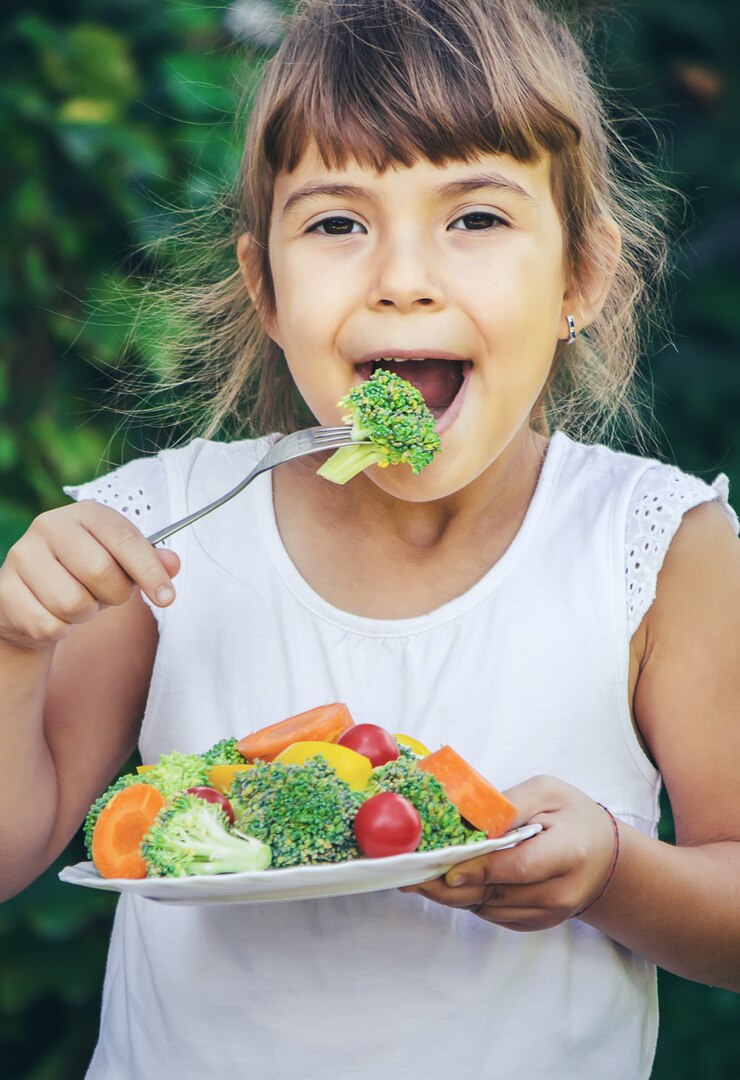 Photo l'enfant mange des légumes en été. mise au point sélective. personnes.