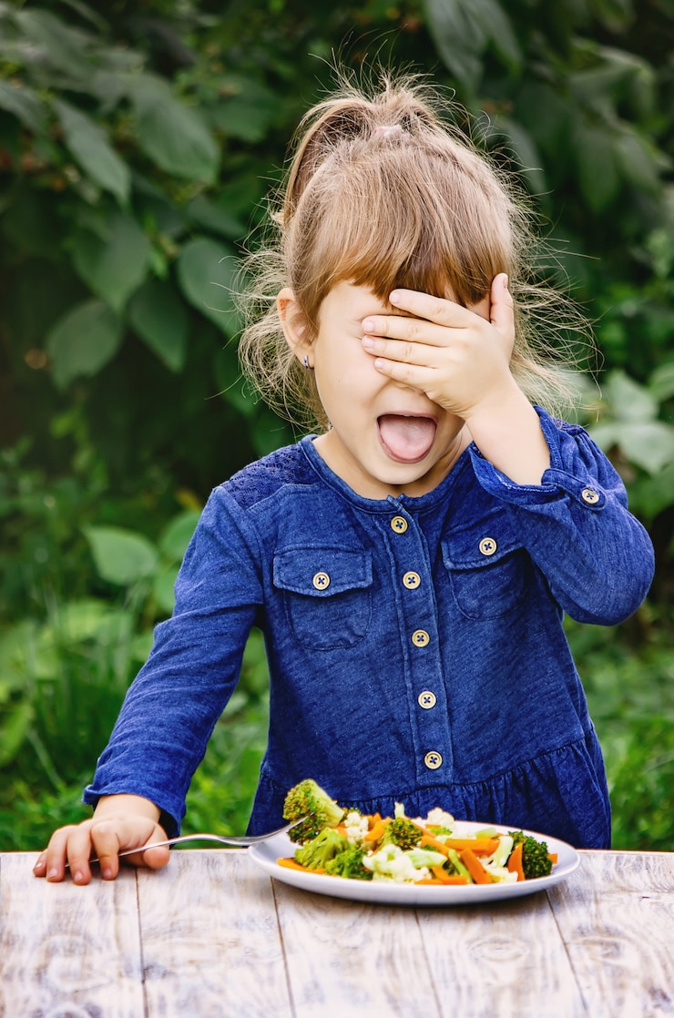Photo l'enfant mange des légumes. photo d'été. mise au point sélective.