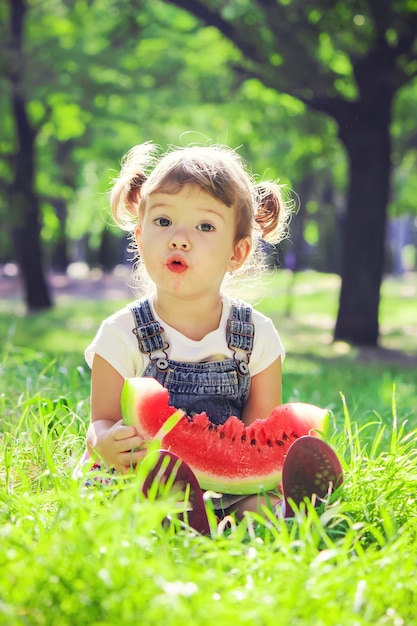 Un enfant mange de la pastèque. Mise au point sélective.