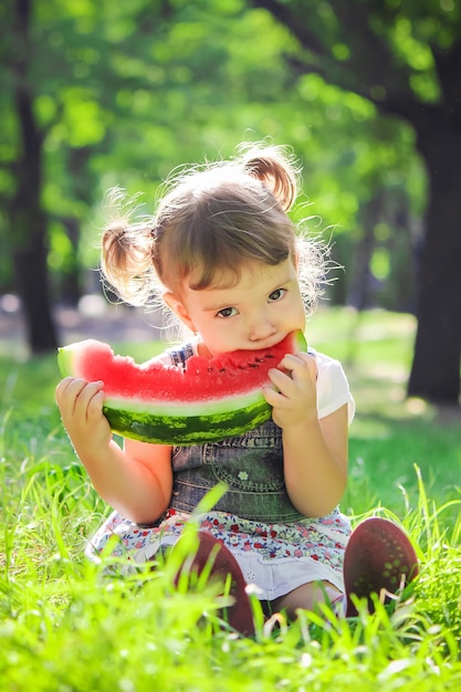 Un Enfant Mange De La Pastèque. Mise Au Point Sélective.