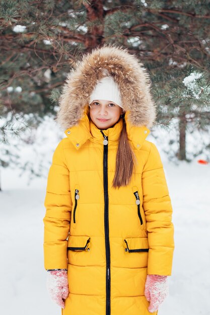 enfant en manteau jaune sur aire de jeux d'hiver