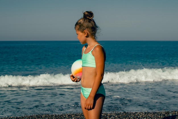 enfant marchant et jouant au bord de la mer en maillot de bain