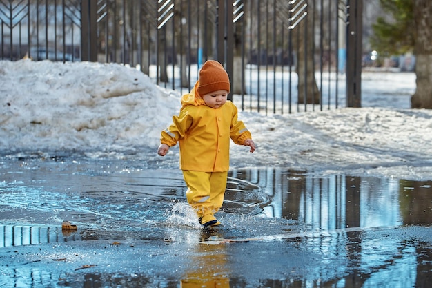 Un enfant marche dans des flaques d'eau en éclaboussant