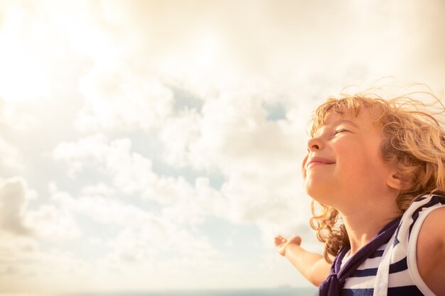 Enfant de marin regardant vers l'avenir contre le ciel d'été