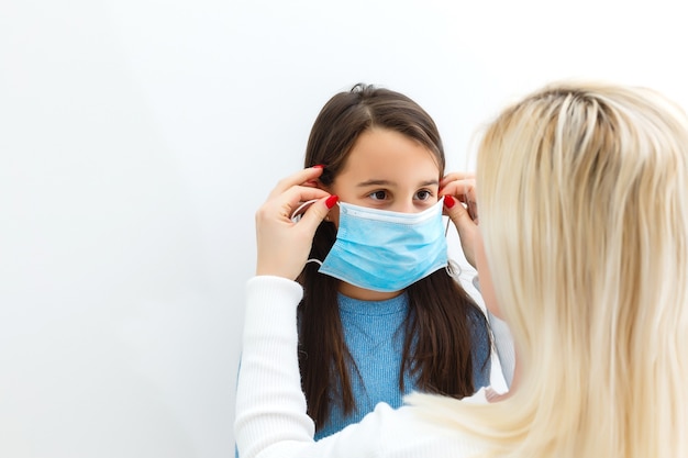 Enfant masqué - protection contre le virus de la grippe. Petite fille caucasienne portant un masque pour se protéger