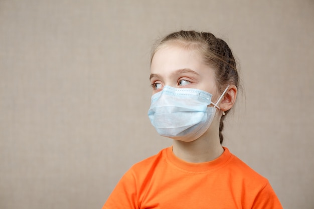 Enfant masqué - protection contre les virus. Petite fille de race blanche portant un masque pour covid 19. Armes biologiques. Pandémie épidémique.