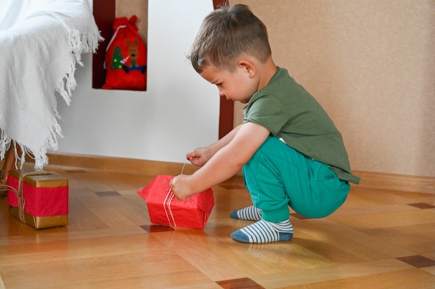 Enfant le matin près de l'arbre de Noël. photo de haute qualité