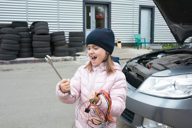 Un enfant mécanicien travaille dans un garage à l'extérieur Services de réparation de voitures Service de voiture