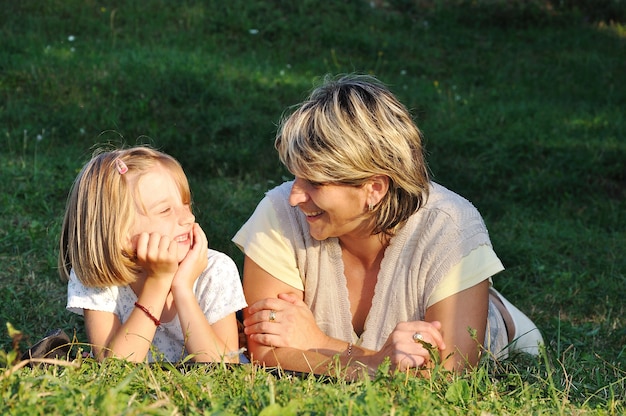 Enfant avec la mère, le bonheur sur le pré vert en été