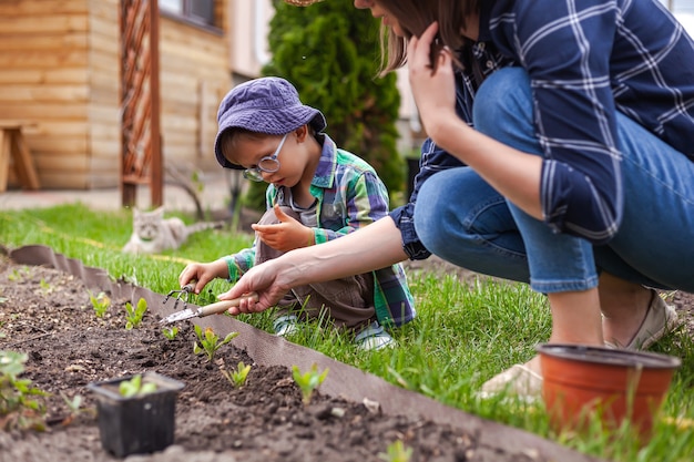 Enfant et mère jardinant dans le potager dans l'arrière-cour