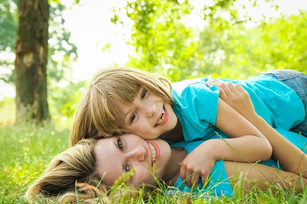 Enfant avec mère jouer à l'extérieur dans un parc sur la mère dans l'herbe