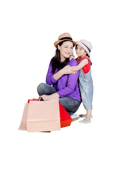 Enfant et mère avec des sacs à provisions en studio