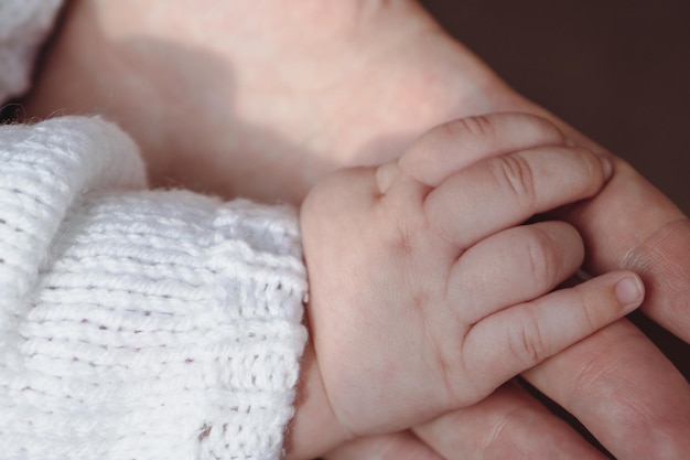 L'enfant et la mère se donnent la main. Soins parentaux. Concept de soins parentaux parentaux. Maternité