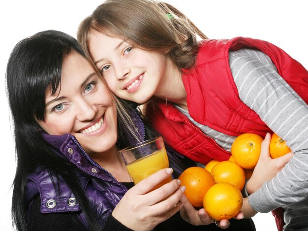 Enfant avec mère tenant des oranges et du jus