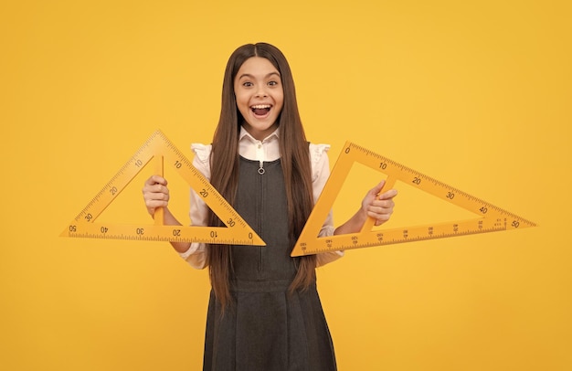 Enfant avec mesure de degré d'angle de triangle surpris adolescente tenir règle retour à l'école