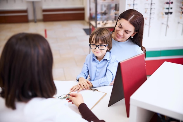 Enfant mettant des lunettes avec cadre bleu foncé