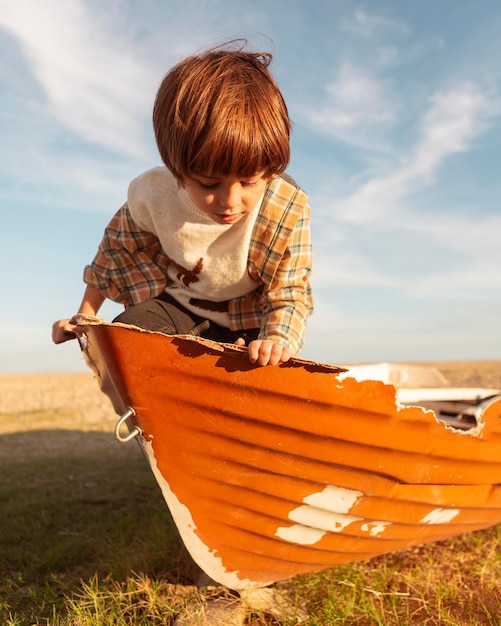 Photo enfant mignon assis en bateau coup moyen