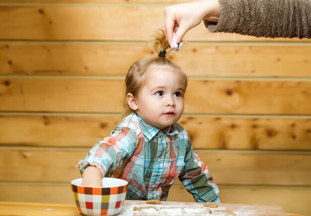 Enfant mignon cuisinant avec de la farine de pâte et un bol sur bois