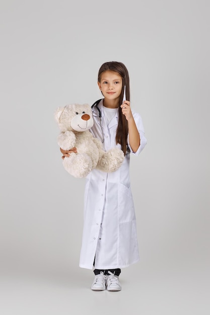 Enfant mignon en manteau de médecin avec stéthoscope