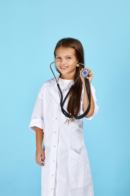 Enfant mignon en manteau de médecin avec stéthoscope