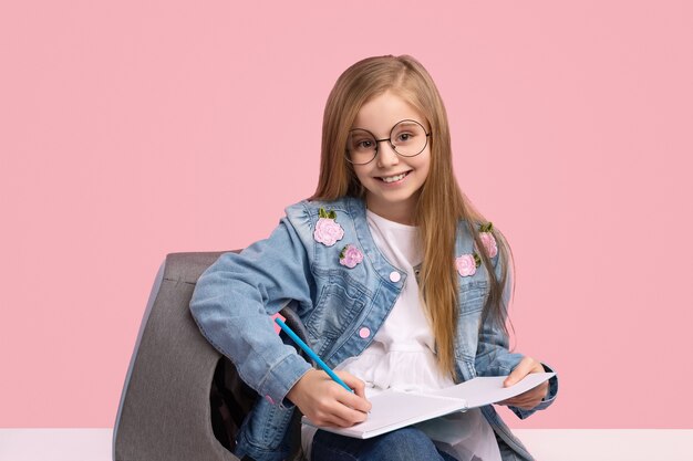 Enfant mignon en tenue à la mode pensant faire ses devoirs