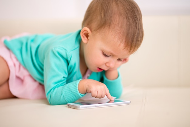 Enfant d'un mois et demi jouant dans un smartphone.