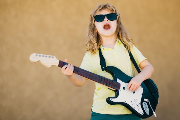 Enfant musicien guitariste jouant de la guitare électrique enfant garçon avec guitare