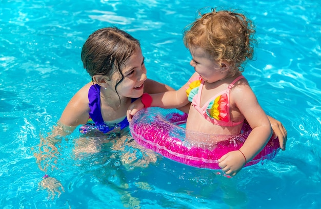 Photo un enfant nage dans une piscine avec un cercle mise au point de sélection