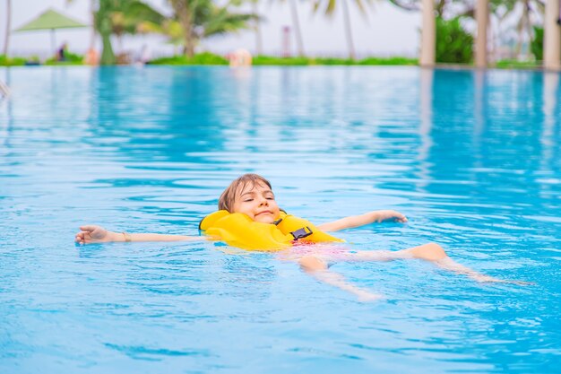 L'enfant nage dans la piscine en été. Mise au point sélective.