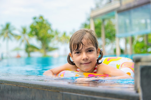 L'enfant nage dans la piscine en été.