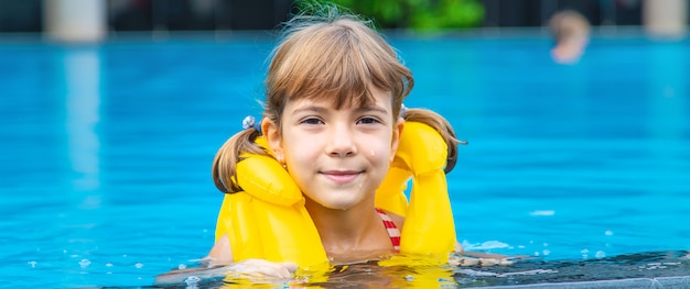 L'enfant nage dans la piscine en été