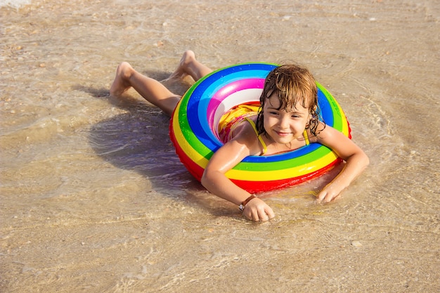 Un Enfant Nage Dans Une Piscine Avec Un Gilet De Sauvetage.