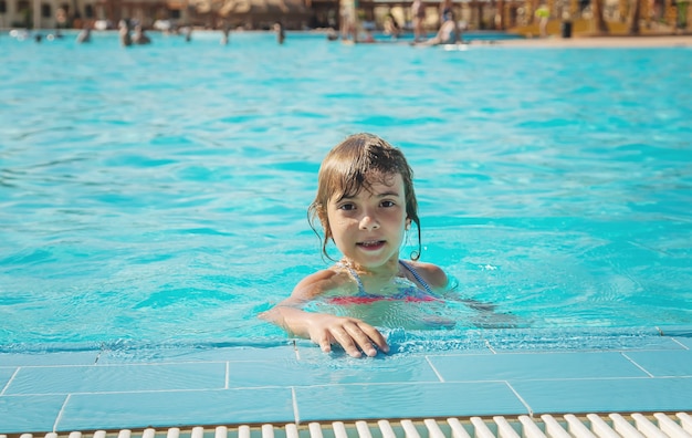 L'enfant nage et plonge dans la piscine. Mise au point sélective.