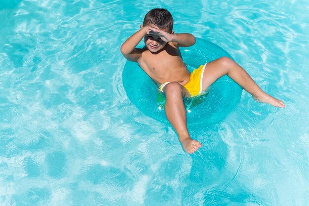 Photo un enfant nageant dans une piscine avec un grand flotteur