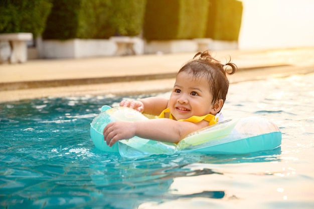 Enfant nager dans la piscine pendant les vacances d'été. Style de vie de petite fille asiatique et détente.