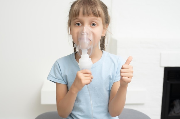 Enfant de neuf ans souffrant d'asthme allergique, inhalant ses médicaments à travers l'entretoise tout en regardant avec ses yeux fatigués.