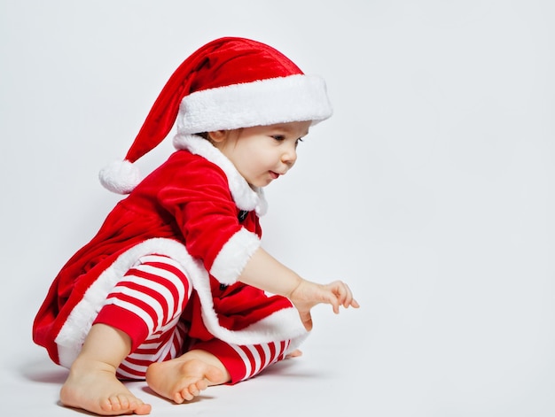 Enfant de noël mignon en bonnet de noel sur fond blanc