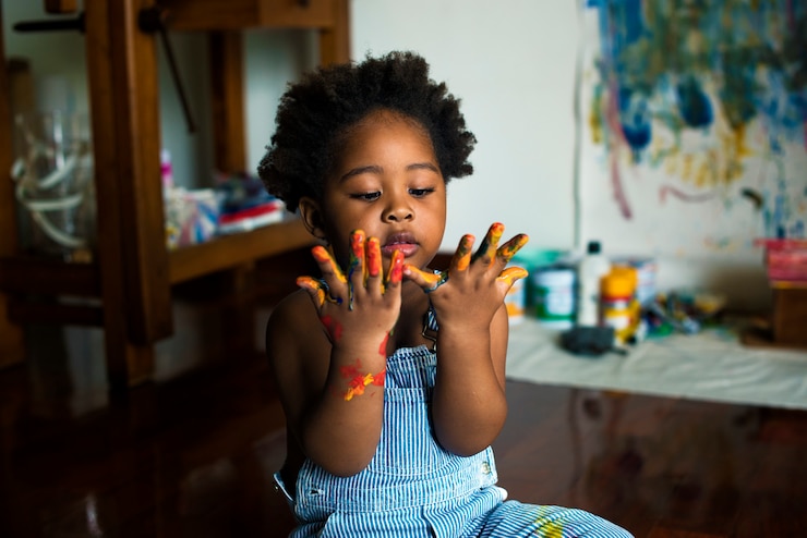 Photo enfant noir appréciant sa peinture