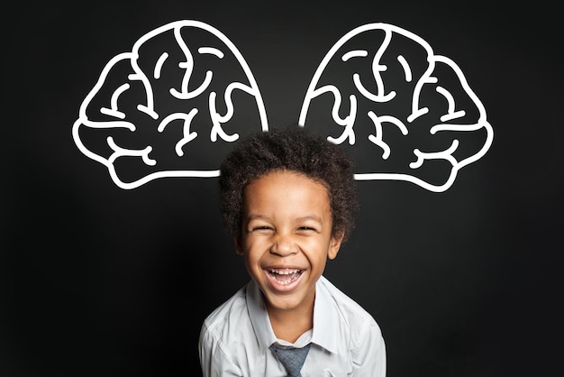 Photo un enfant noir avec un grand cerveau qui rit.