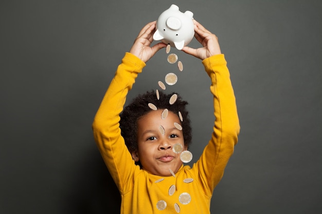 Photo un enfant noir heureux et une pluie d'argent sur un fond noir