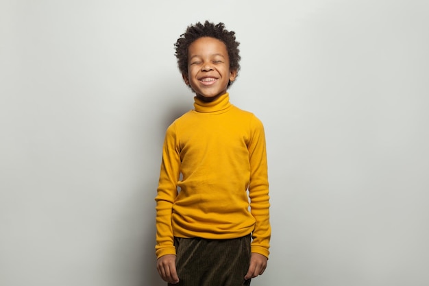 Un enfant noir qui rit Un petit garçon heureux sur un fond blanc