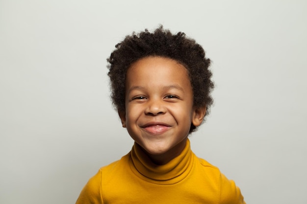 Un enfant noir riant sur un fond blanc