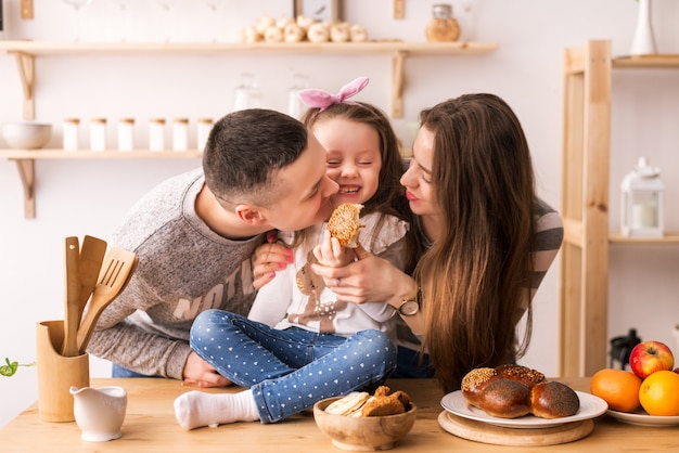 L'enfant nourrit les parents dans la cuisine