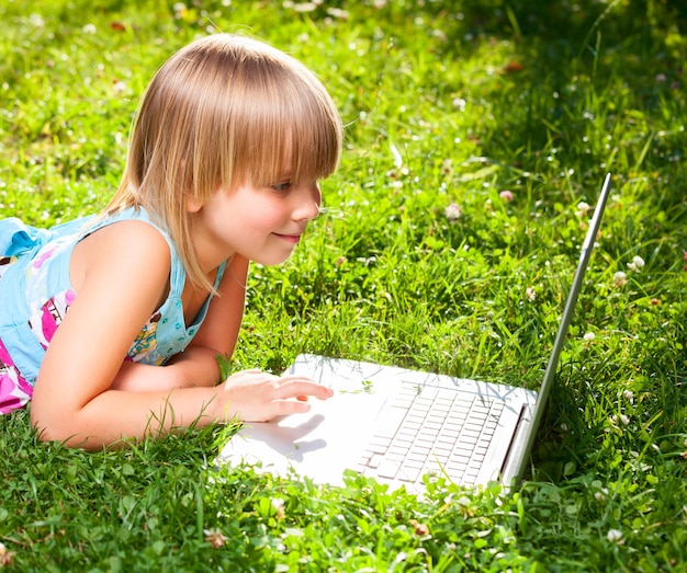 Enfant avec ordinateur à l'extérieur