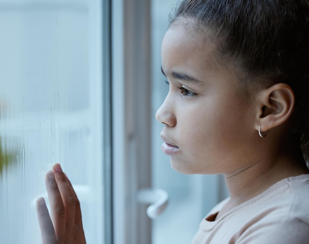 Un enfant oublié devrait être une infraction punissable Photo d'une petite fille commençant par la fenêtre à la maison triste