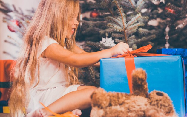 Enfant ouvrant des cadeaux de Noël