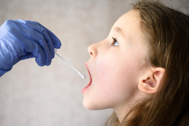 Un enfant ouvre la bouche pour le test PCR COVID19