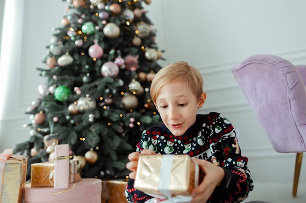 un enfant ouvre un cadeau de Noël